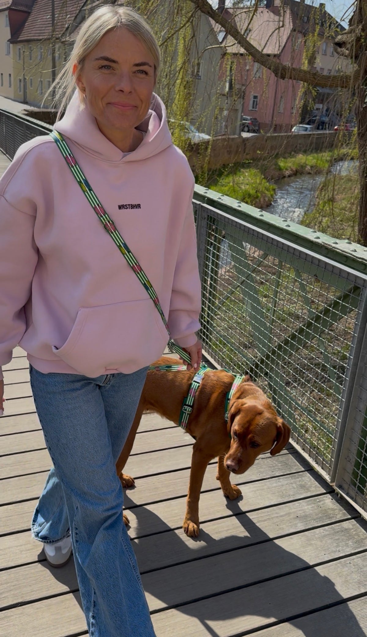 Frau mit Labrador laufen über Brücke, Hund trägt Geschirr aus der Designerlinie SALTY