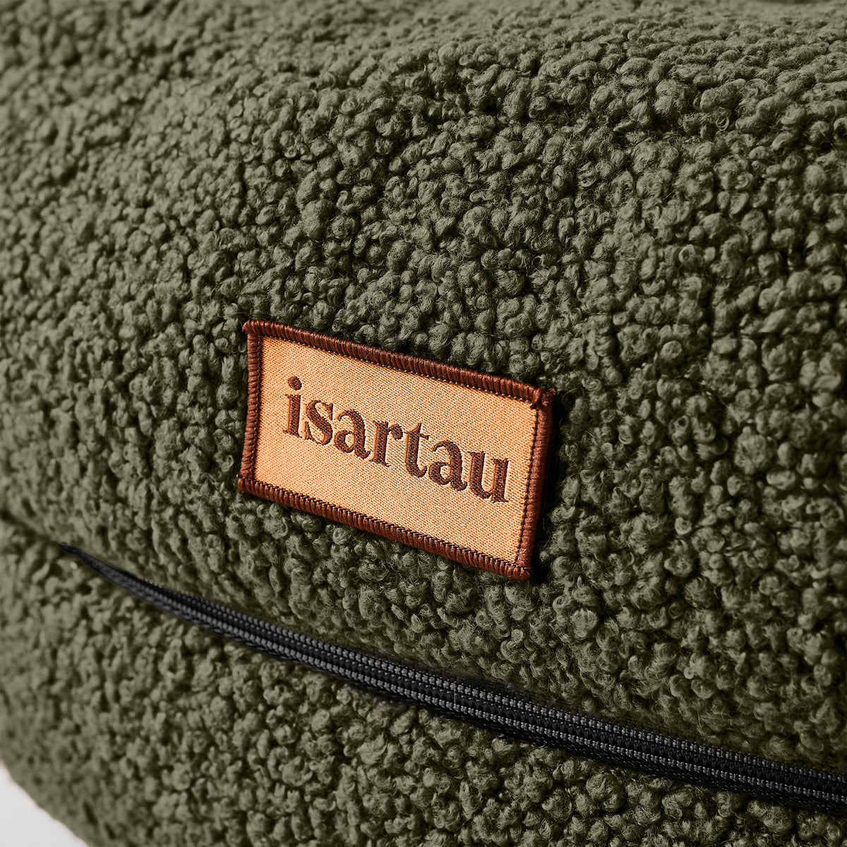 isartau Detail Hundebett Bagelbettchen mit abnehmbarem olivgrünem Teddystoffbezug, Fokus auf isartau Logo