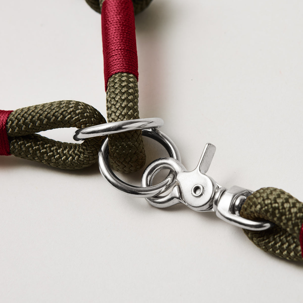 Detail Zugstopp Halsband mit Tauleine Olive Grove Burgunder, olivfarbenes Kletterseil mit burgunderfarbener Takelung Fokus auf silberfarbene Ringe und Karabiner