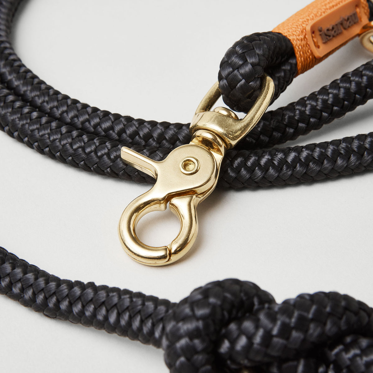 Detail Hundeleine Black Mamba Rost Orange, schwarzes Tau mit rost-oranger Takelung, Fokus auf goldfarbene Karabiner und Tau