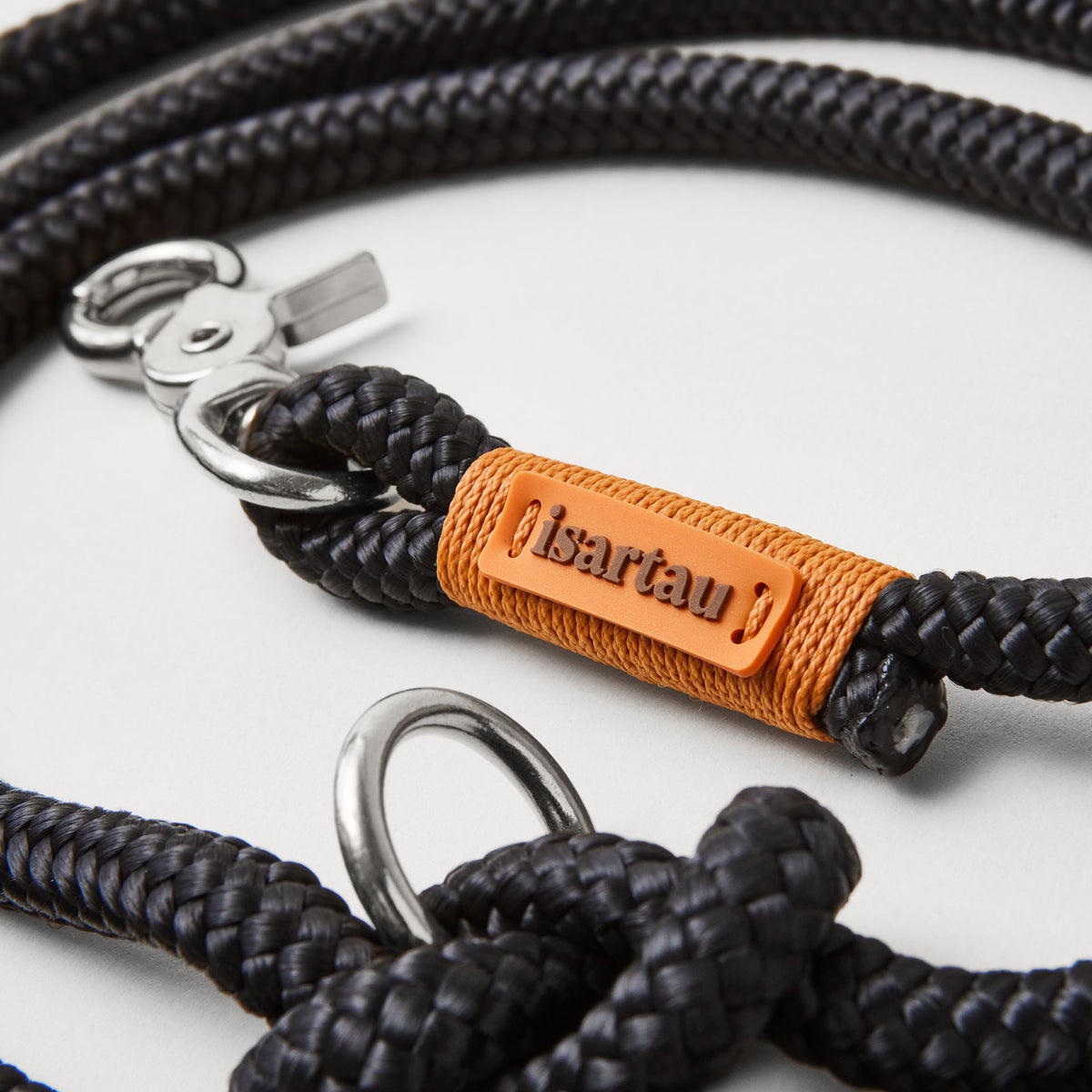Detail Hundeleine Black Mamba Rost Orange, schwarzes Tau mit rost-oranger Takelung, Fokus auf isartau Logo