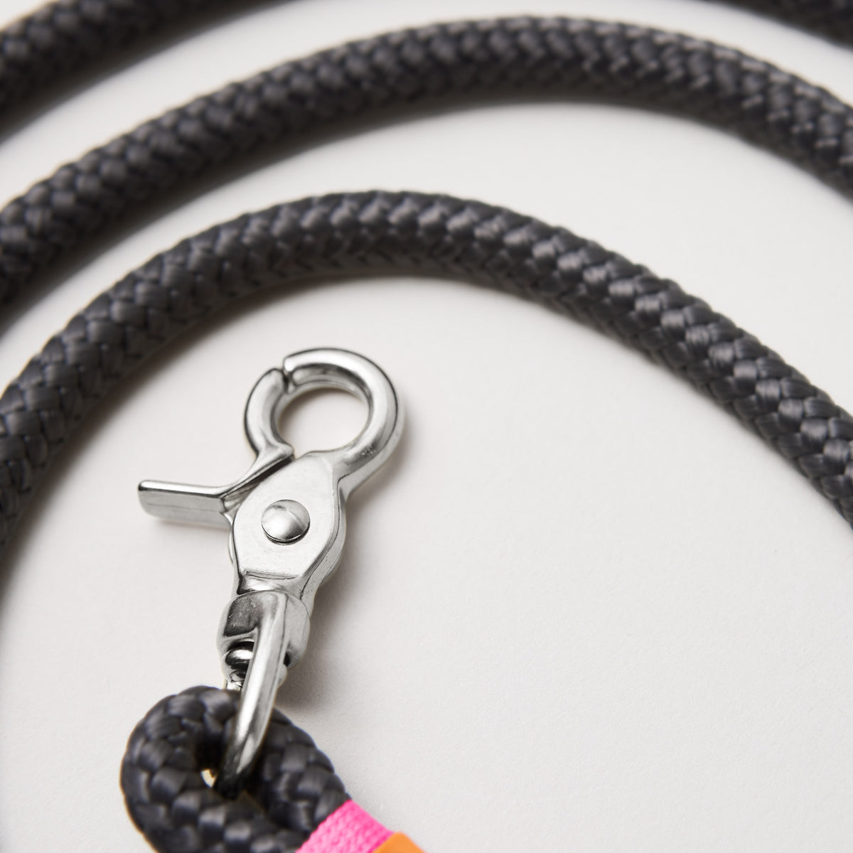 Detail Hundeleine Heavens Rock Neonpink, dunkelgraues Tau mit neonpinker Takelung, Fokus auf silberfarbene Karabiner und Tau
